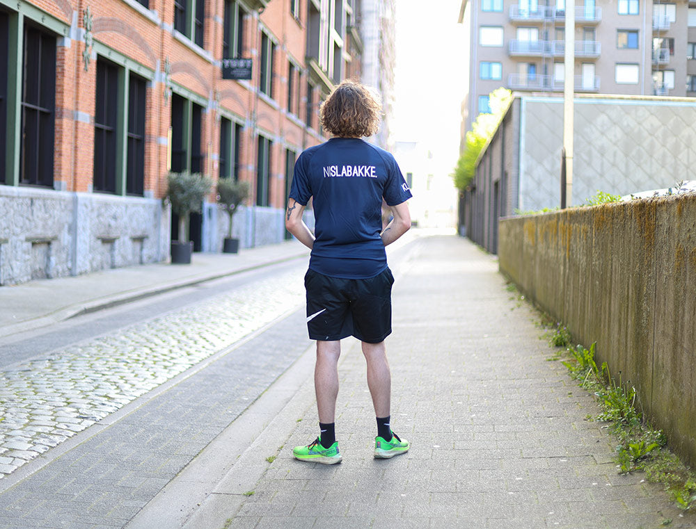 Man met een blauwe loopshirt met opdruk NISLABAKKE.