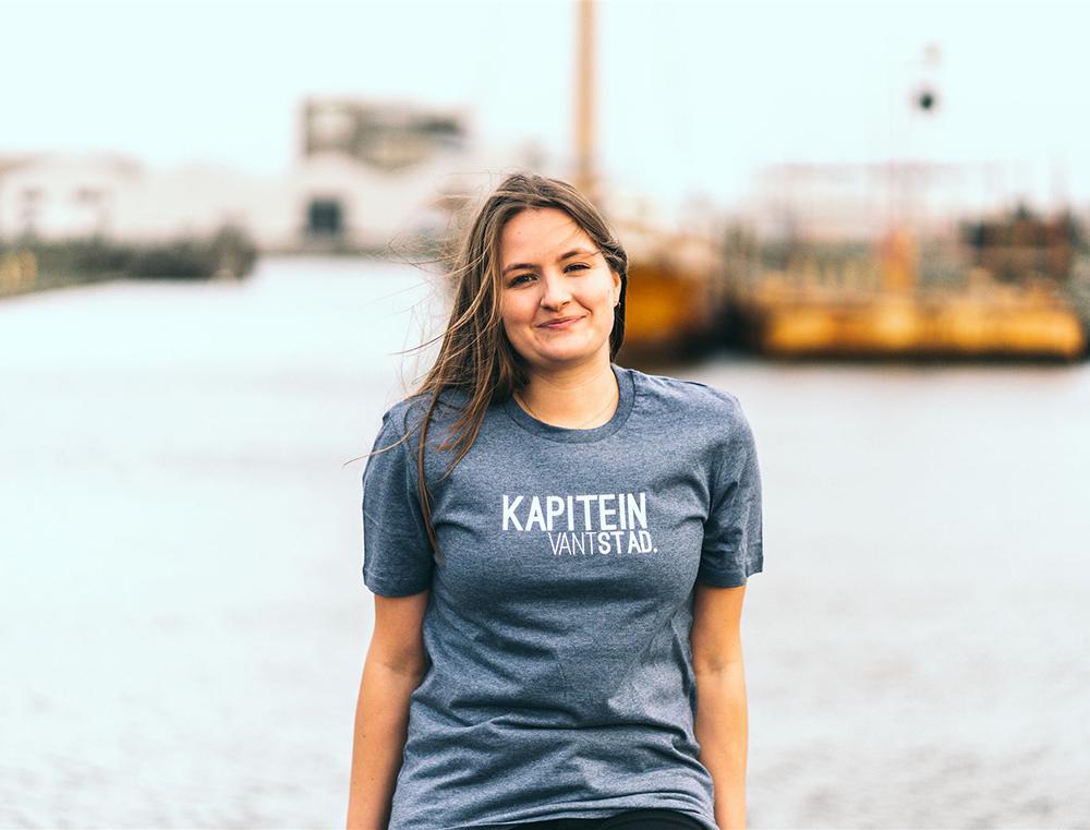 Vrouw met blauwe T-shirt met opdruk KAPITEINVANTSTAD.