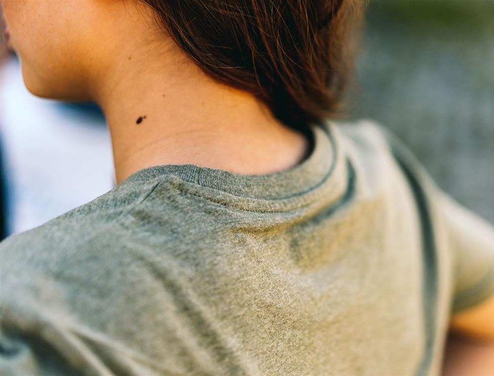 Close-up van kaki T-shirt met opdruk KEMDEUST.