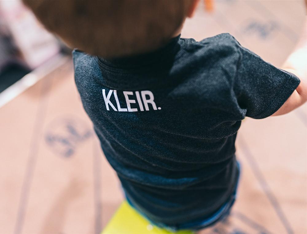 Close-up van donkergrijze T-shirt met KLEIR. logo in de nek