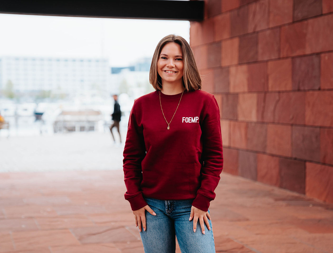 Vrouw met bordeaux trui met opdruk FOEMP.