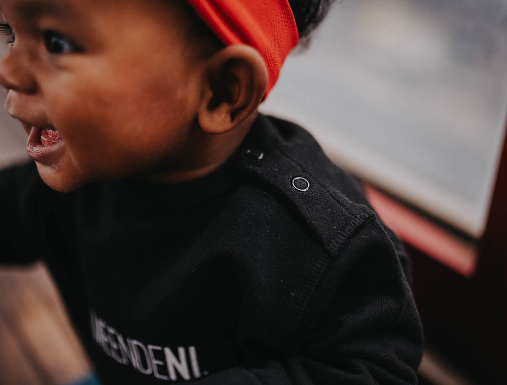 Close-up van een zwarte baby trui.