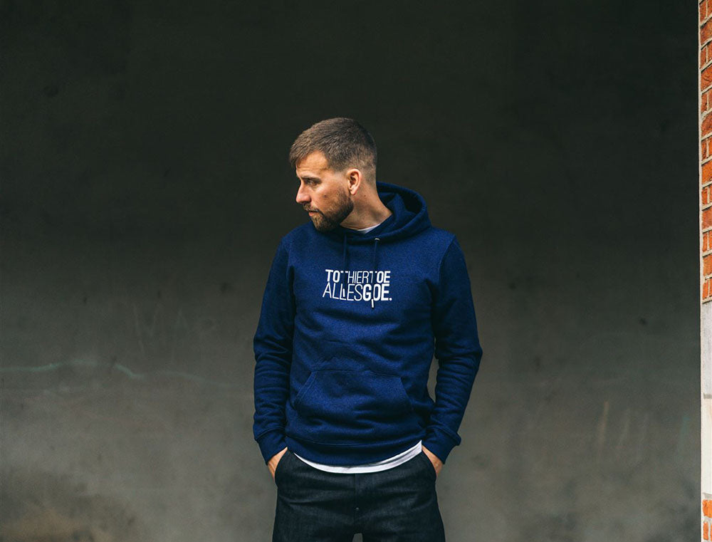 Tourist met een donkerblauwe hoodie met opdruk TOTHIERTOEALLESGOE.