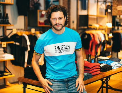 Man met blauwe T-shirt met opdruk ZWIEREN METDIESPIEREN.