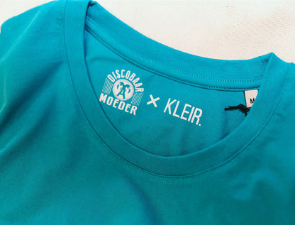 Close-up van logo's Discobaar A moeder x KLEIR. in een blauwe T-shirt