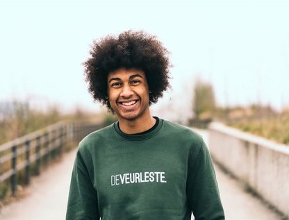 Man met een groene trui met opdruk DEVEURLESTE.