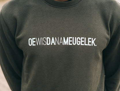 Close-up van een kaki trui met opdruk OEWISDANAMEUGELEK.