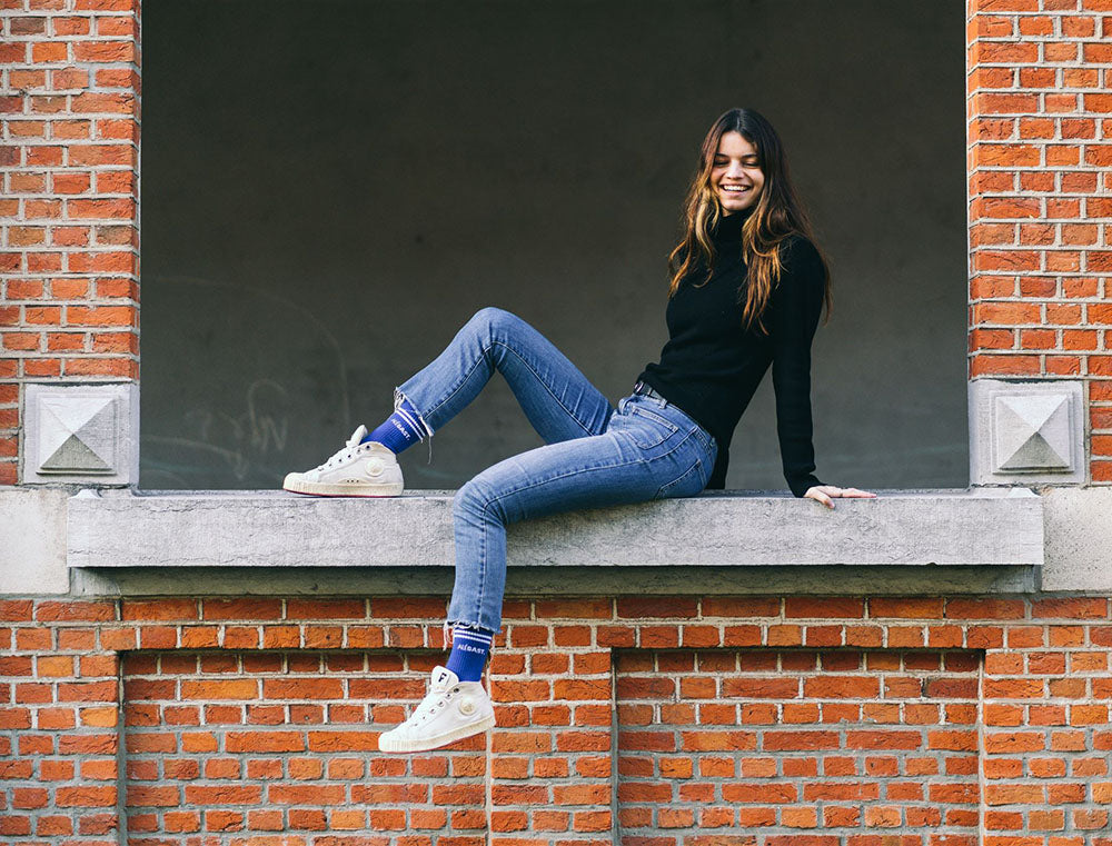 Vrouw met blauwe sokken met opdruk ALEGAST.