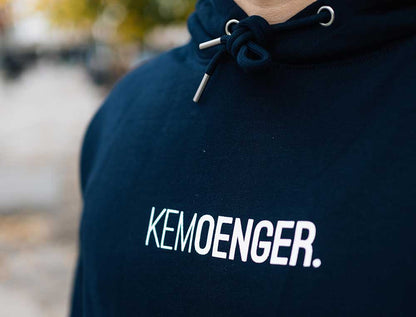 Man met een donkerblauwe hoodie met opdruk KEMOENGER.