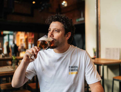Man met een witte T-shirt met opdruk d'ANVERS.