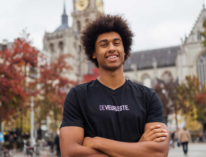 Man met een zwarte T-shirt met opdruk DEVEURLESTE.
