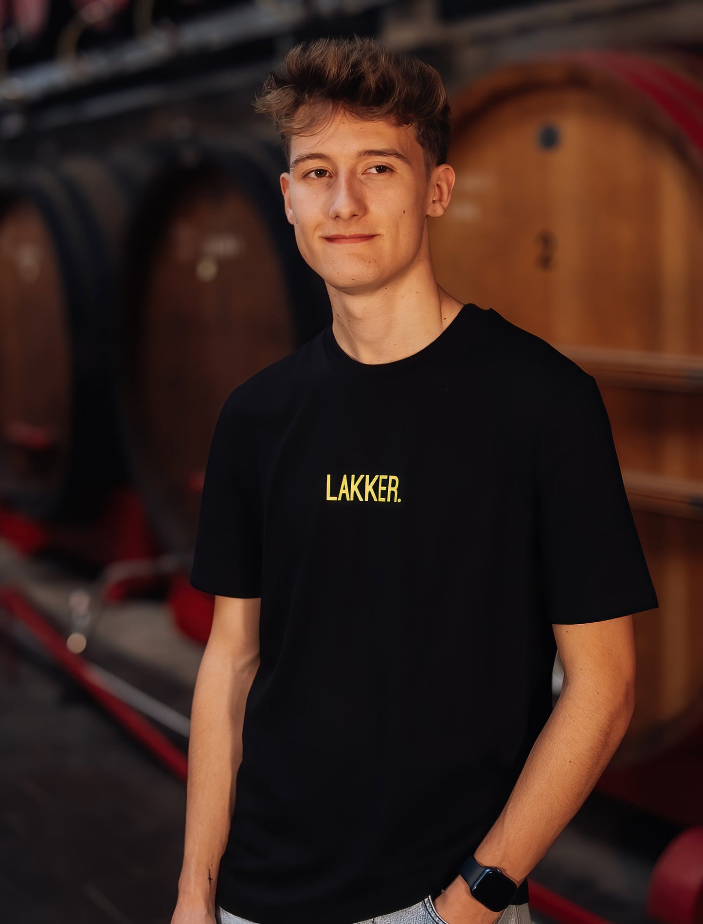 Man met zwarte T-shirt met gele opdruk LAKKER.