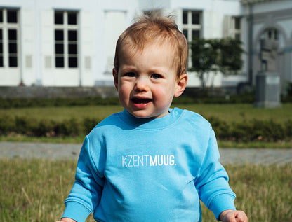 Baby met blauwe sweater met opdruk KZENTMUUG.