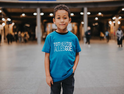 Jongen met blauwe T-shirt met opdruk TOTHIERTOEALLESGOE.