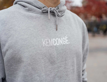 Close-up van een grijze hoodie met opdruk KEMCONGE.