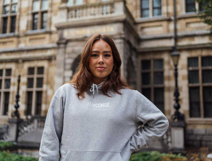 Vrouw met een grijze hoodie met opdruk KEMCONGE.