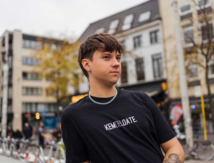 Man met een zwarte T-shirt met opdruk KEMDELOATE.