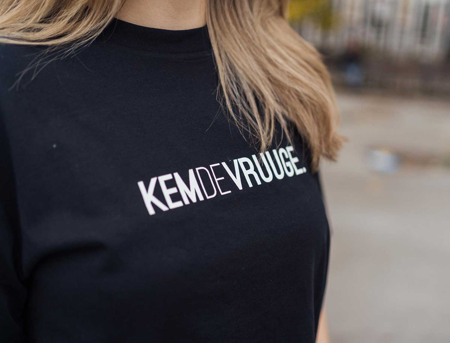 Close-up van een vrouw met zwarte T-shirt met opdruk KEMDEVRUUGE.