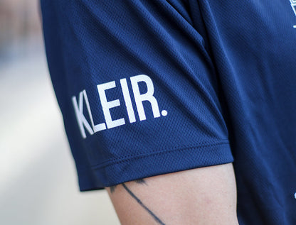 Close-up van een blauwe mouw met opdruk KLEIR.