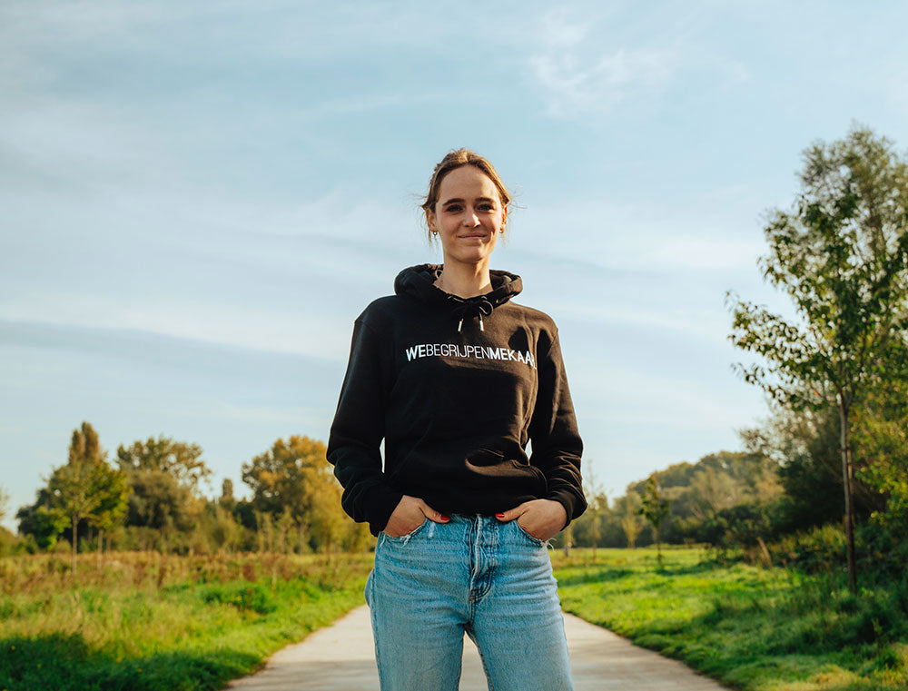 Vrouw met zwarte hoodie met opdruk WEBEGRIJPENMEKAAR.