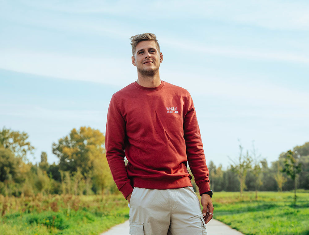Man met rode sweater met opdruk MIJNSTAD.
