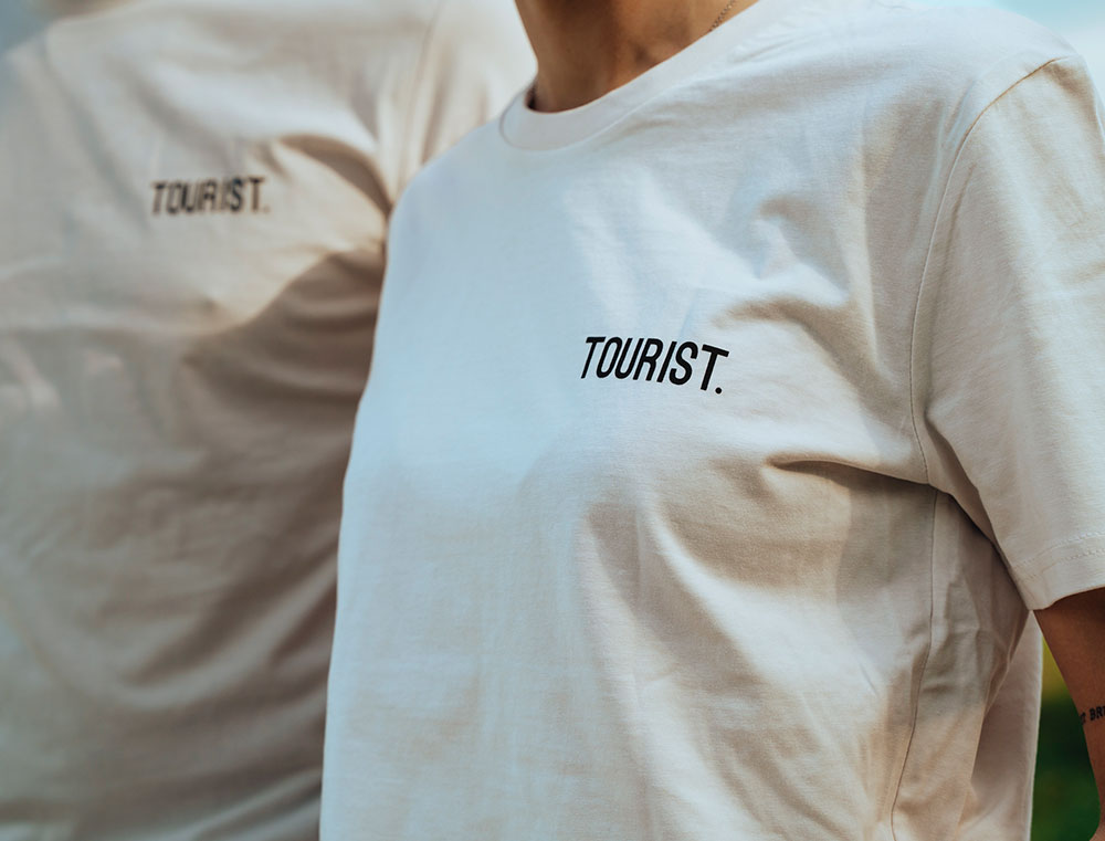Close-up van witte T-shirt met opdruk TOURIST.