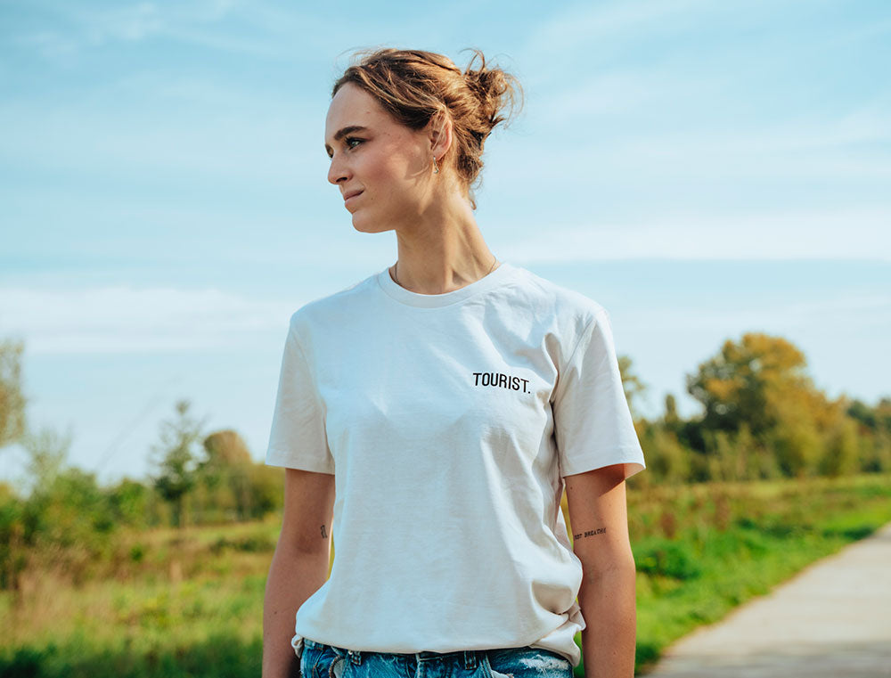 Vrouw met witte T-shirt met opdruk TOURIST.