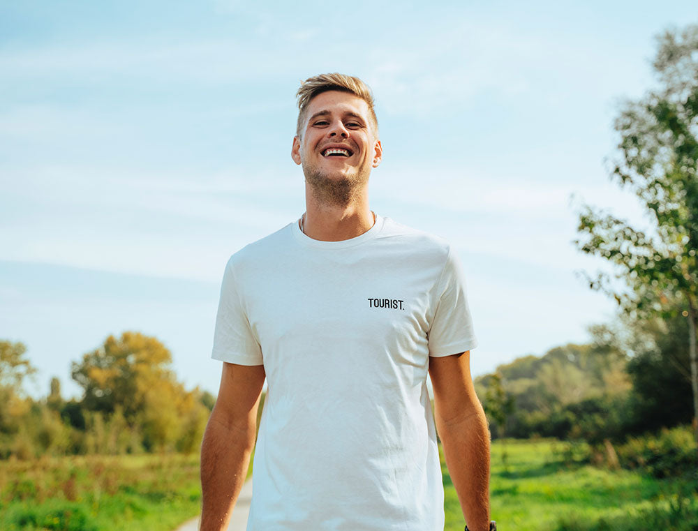 Man met witte T-shirt met opdruk TOURIST.