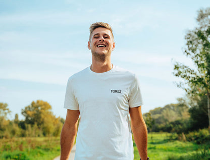 Man met witte T-shirt met opdruk TOURIST.