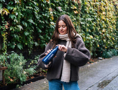 Vrouw met een donkerblauwe drinkfles met opdruk KZENTMUUG.