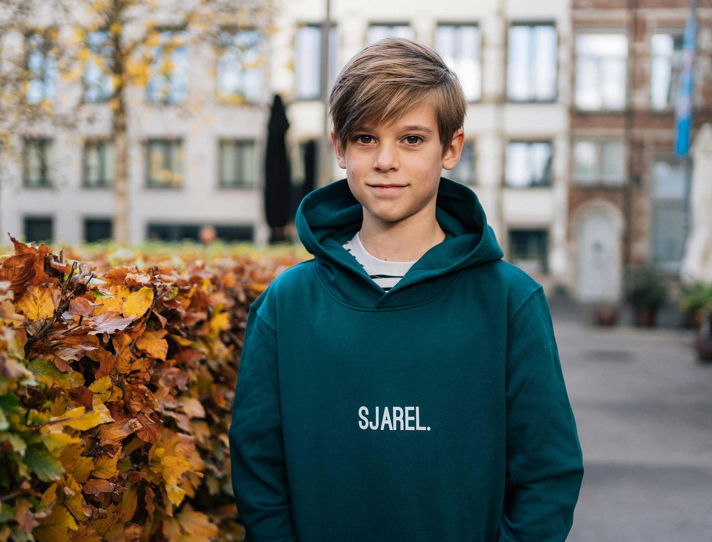 Jongen met een groene hoodie met opdruk SJAREL. voor kinderen