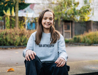 Meisje met een grijze sweater met opdruk Van Antwerpen met typische GVA letters