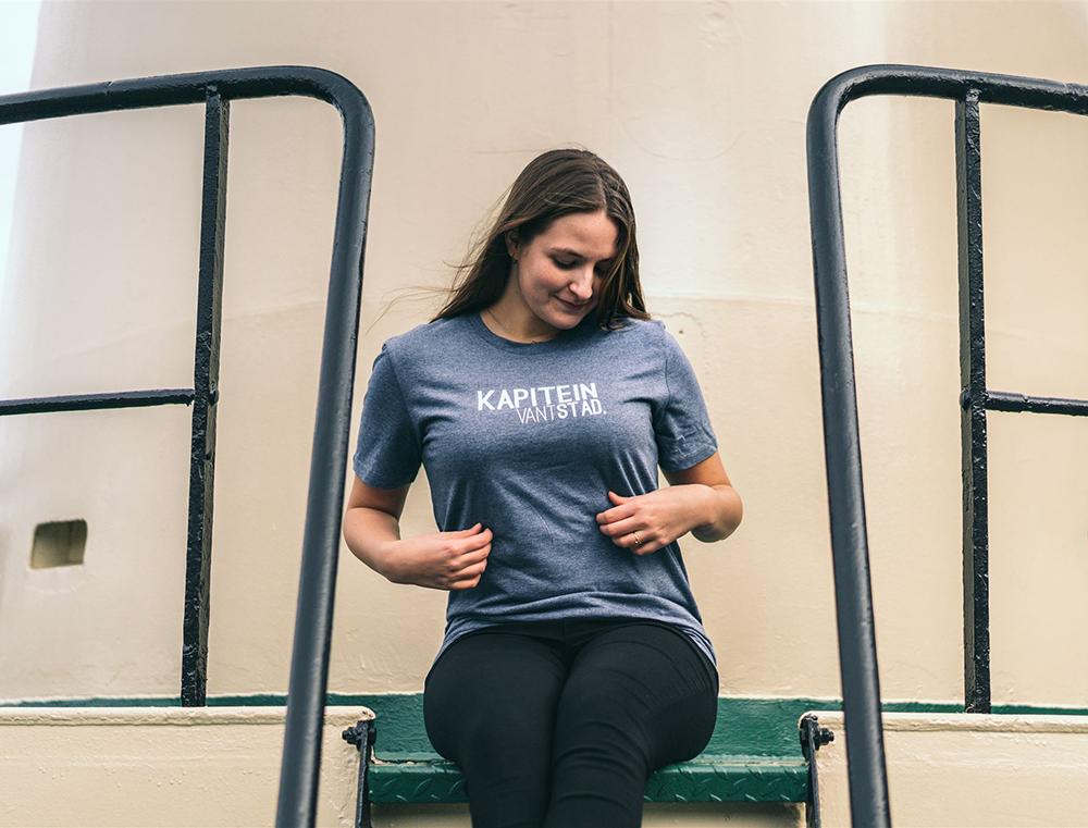 Vrouw met blauwe T-shirt met opdruk KAPITEINVANTSTAD.