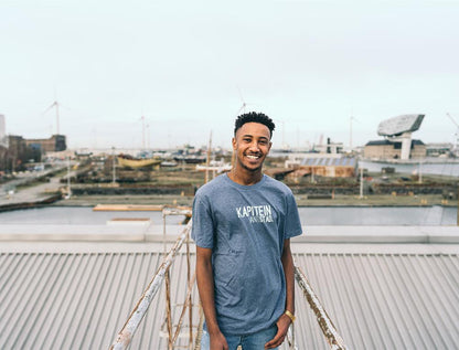 Man met blauwe T-shirt met opdruk KAPITEINVANTSTAD.