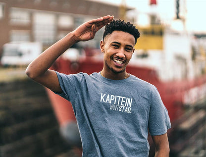 Man met blauwe T-shirt met opdruk KAPITEINVANTSTAD.