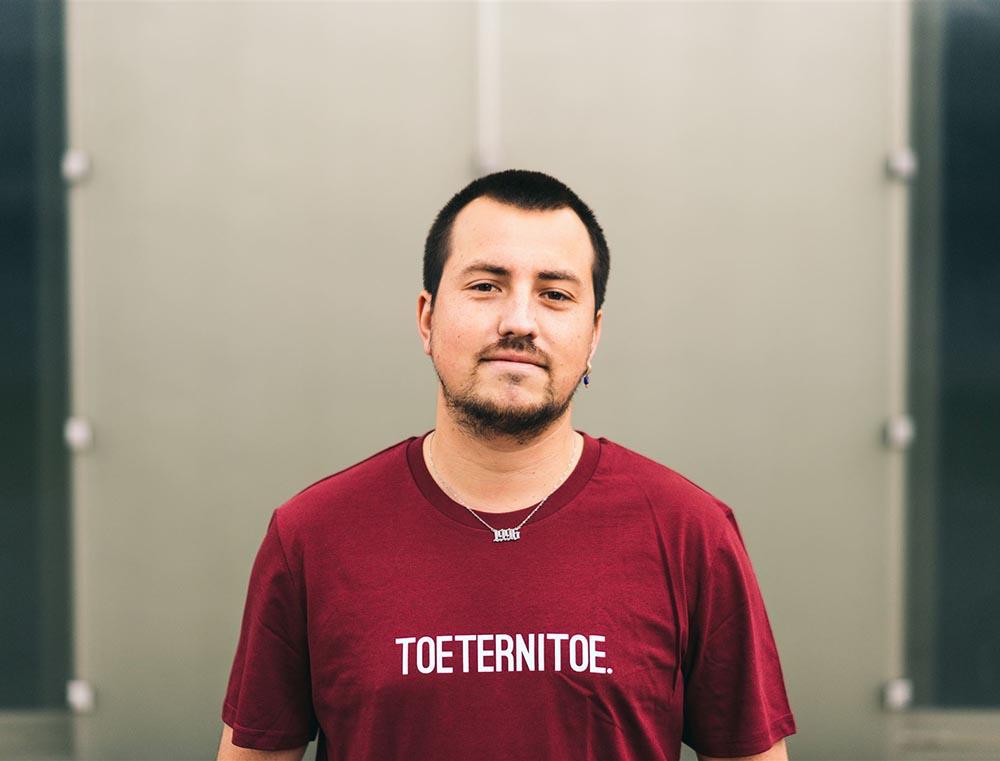 Man met bordeaux T-shirt met opdruk TOETERNITOE.