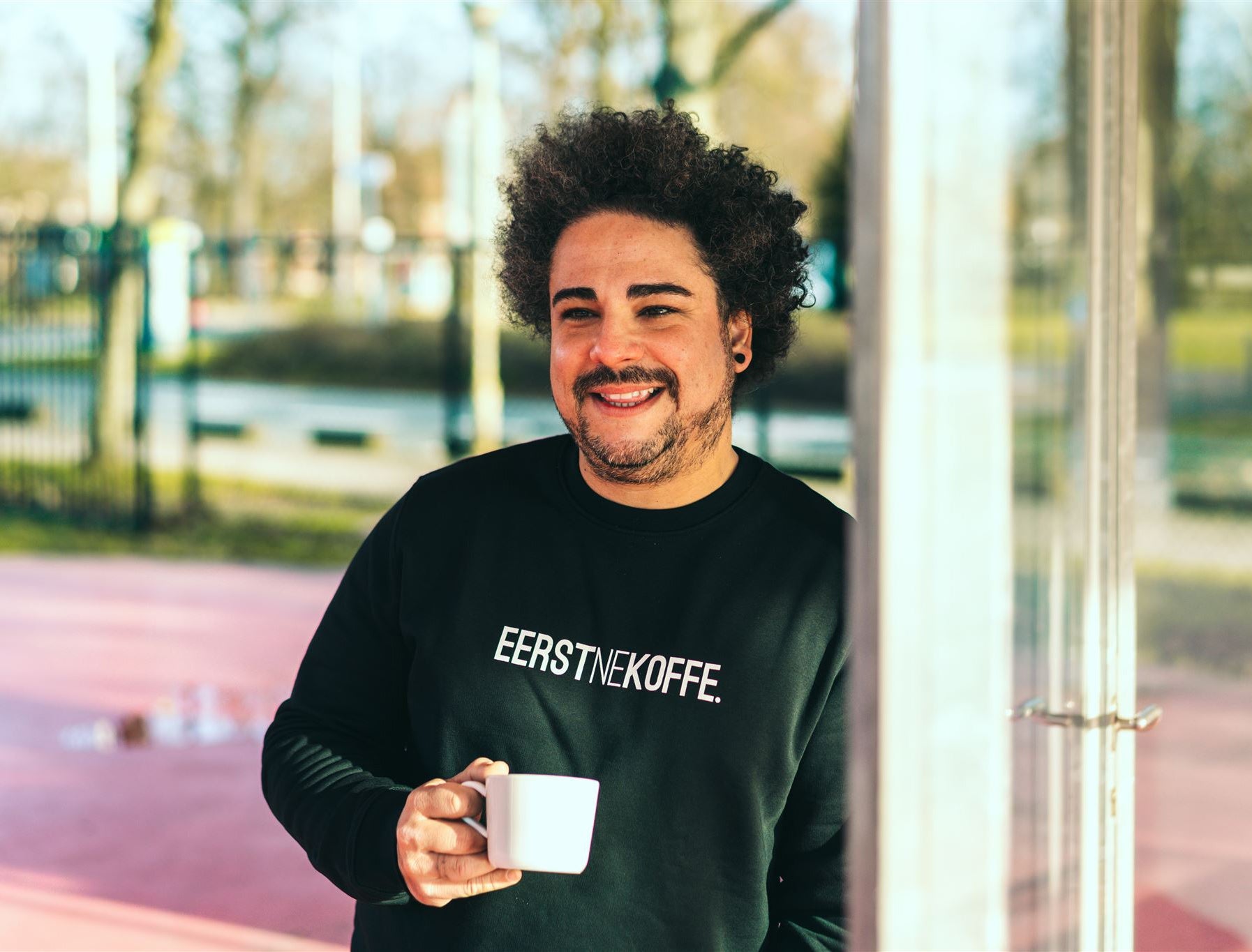Man met een zwarte trui met opdruk EERSTNEKOFFE.