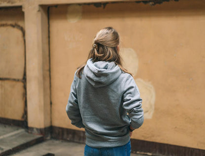 Achteraanzicht van vrouw met grijze hoodie.