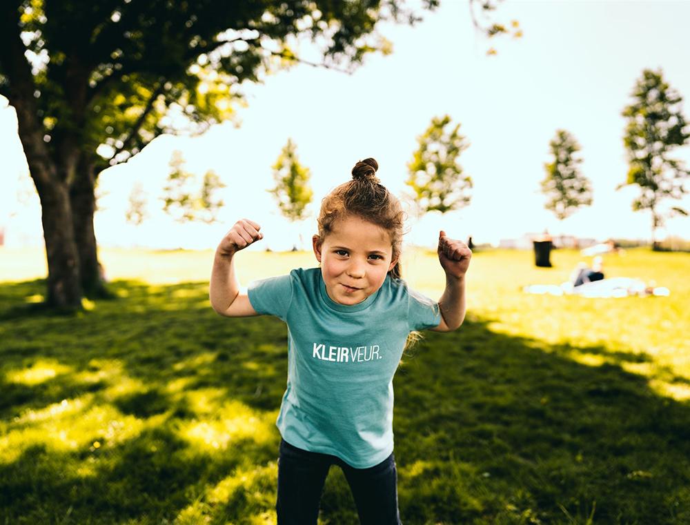 Meisje met groene T-shirt met opdruk KLEIRVEUR.