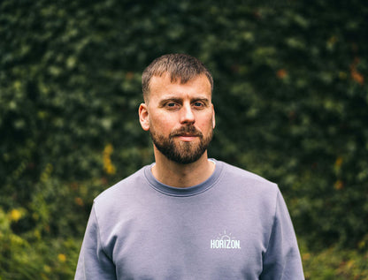Man met grijze trui met opdruk HORIZON.