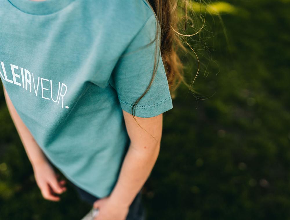 Meisje met groene T-shirt met opdruk KLEIRVEUR.