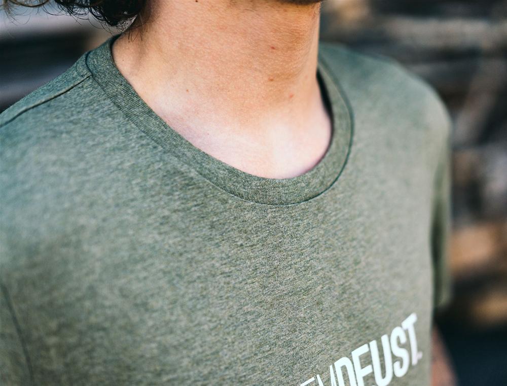 Close-up van kaki T-shirt met opdruk KEMDEUST.