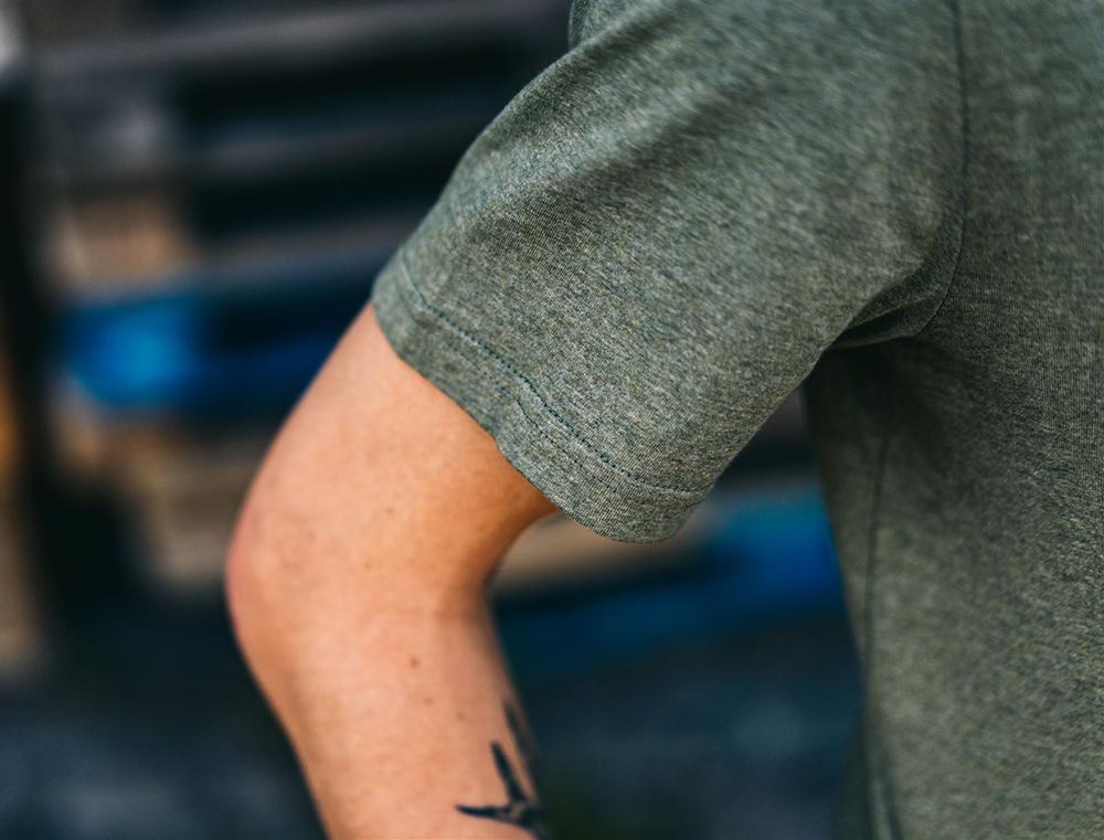 Close-up van kaki T-shirt met opdruk KEMDEUST.