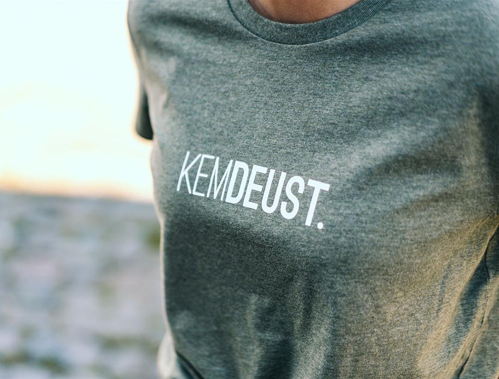 Close-up van kaki T-shirt met opdruk KEMDEUST.