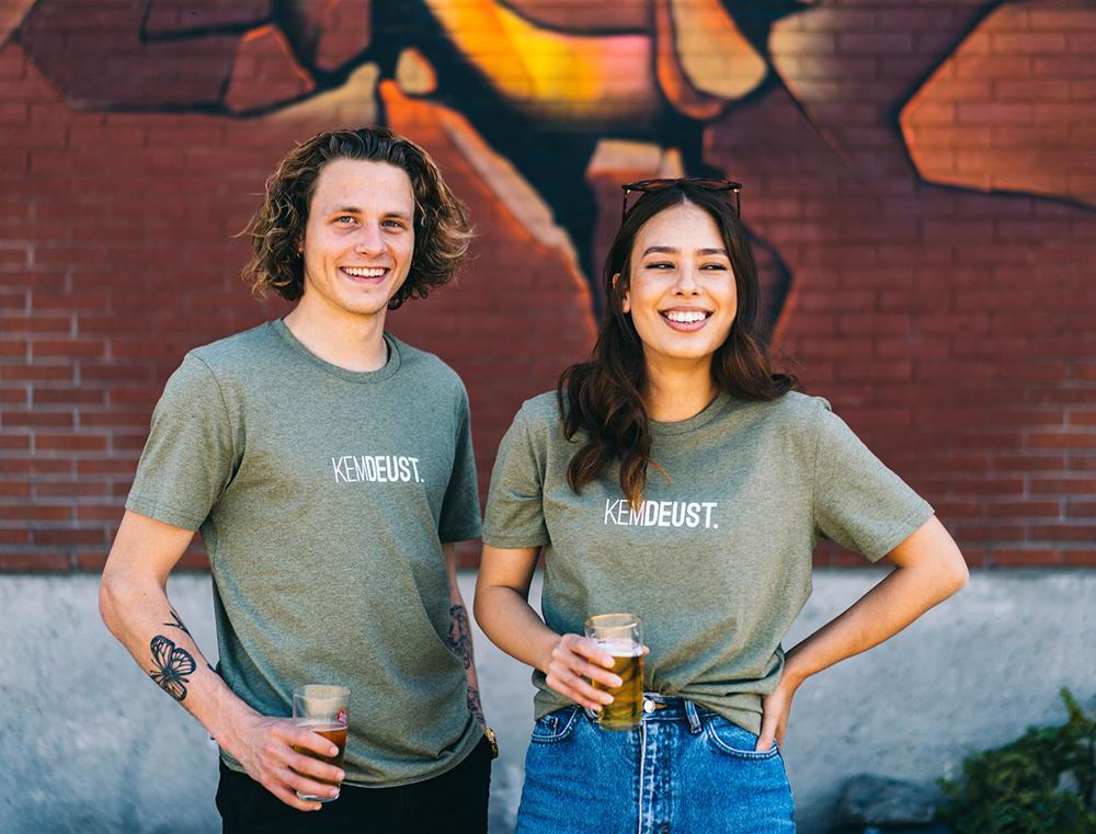 Man en vrouw met kaki T-shirt met opdruk KEMDEUST.