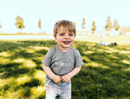 Jongen met t-shirtje met opdruk KLEIRVEUR.