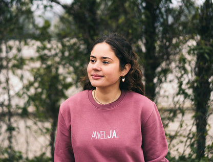 Vrouw met bordeaux trui met opdruk AWELJA.