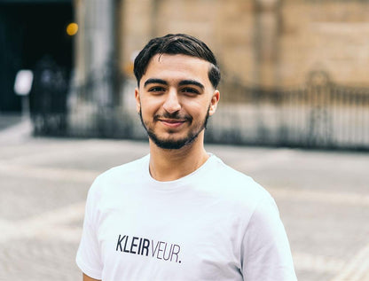 Man met witte T-shirt met opdruk 'KLEIRVEUR.'