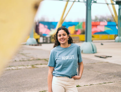 Vrouw met lichtblauwe T-shirt met opdruk REGELET.