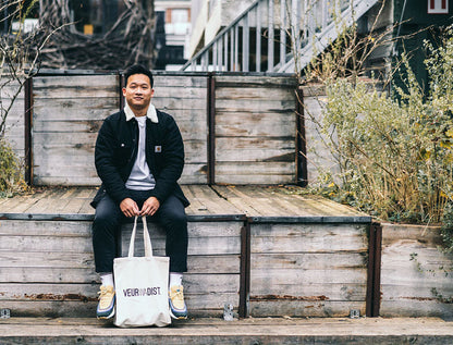 Man met totebag met opdruk VEURWADIST.